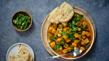 Vega recept: Gele linzencurry met pompoen, stukjes dés en platbrood