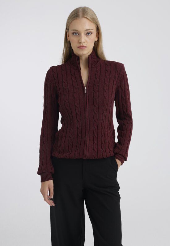 Dames vest in bordeauxrode kabelbreinafdruk met ritssluiting, gedragen door een model met zwarte broek.