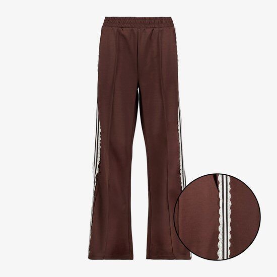Bruine joggingbroek met witte kanten biezen langs de zijkanten en een elastische tailleband. Zoom met ingeknipte kanten details.